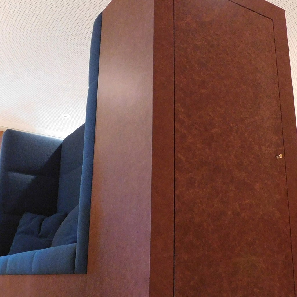 Schrank und eine Sitzbank verkleidet mit Leder in braun.