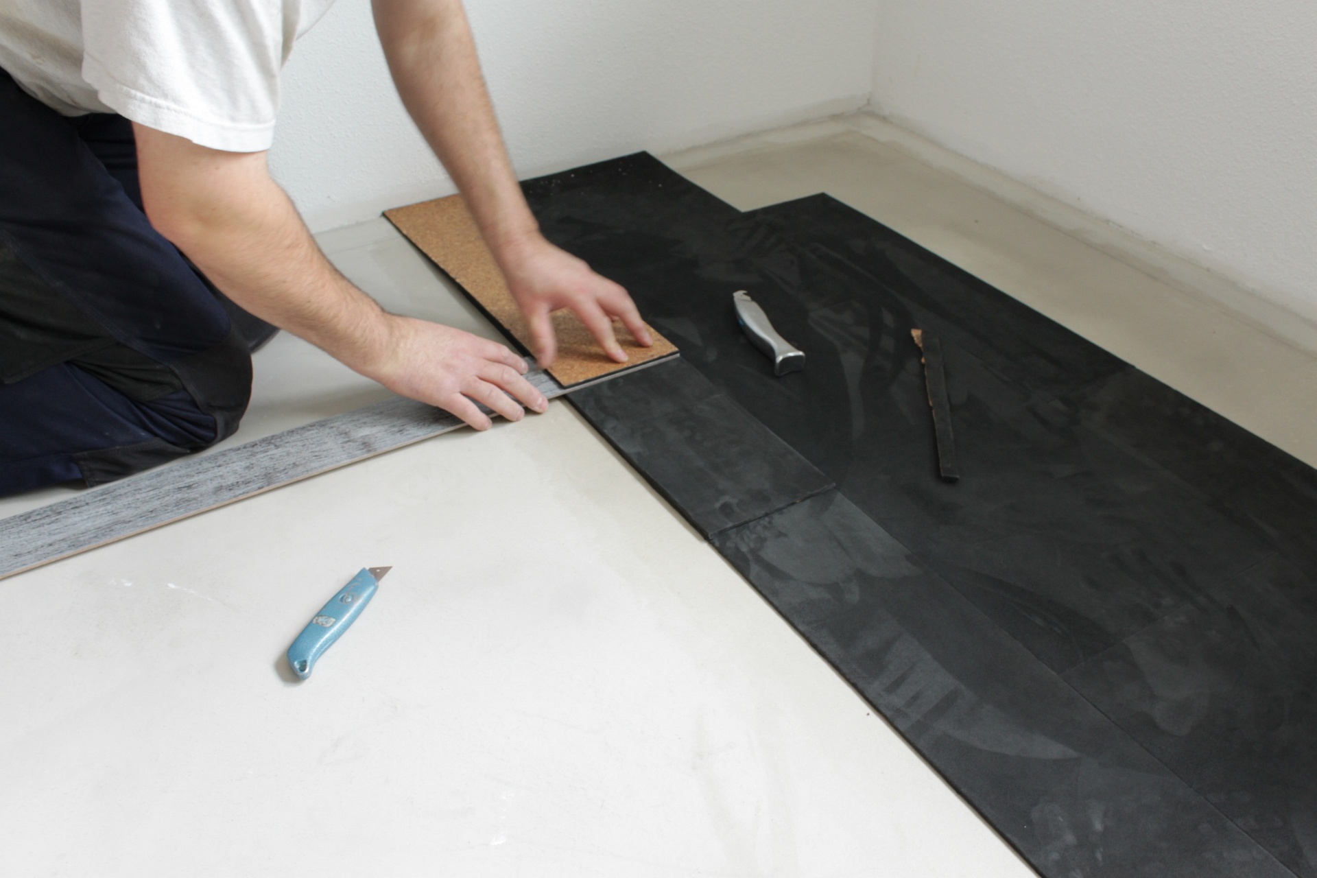 Verlgearbeiten von Lederboden Manufaktur Fachkraft, eines Velourlederbodens in schwarz.